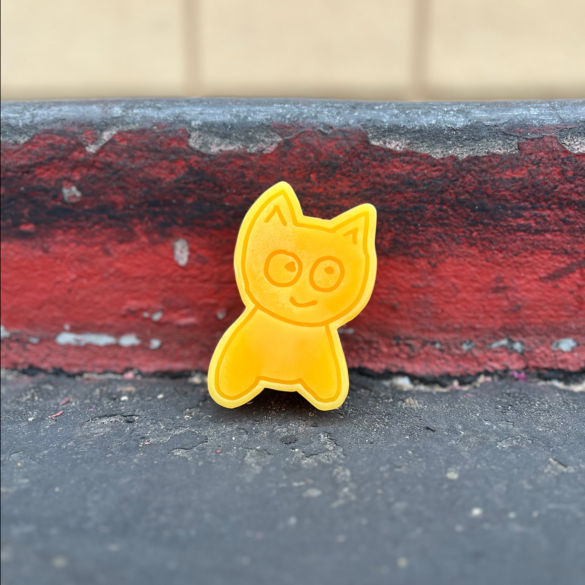 Big Cat skate wax leaning against red curb