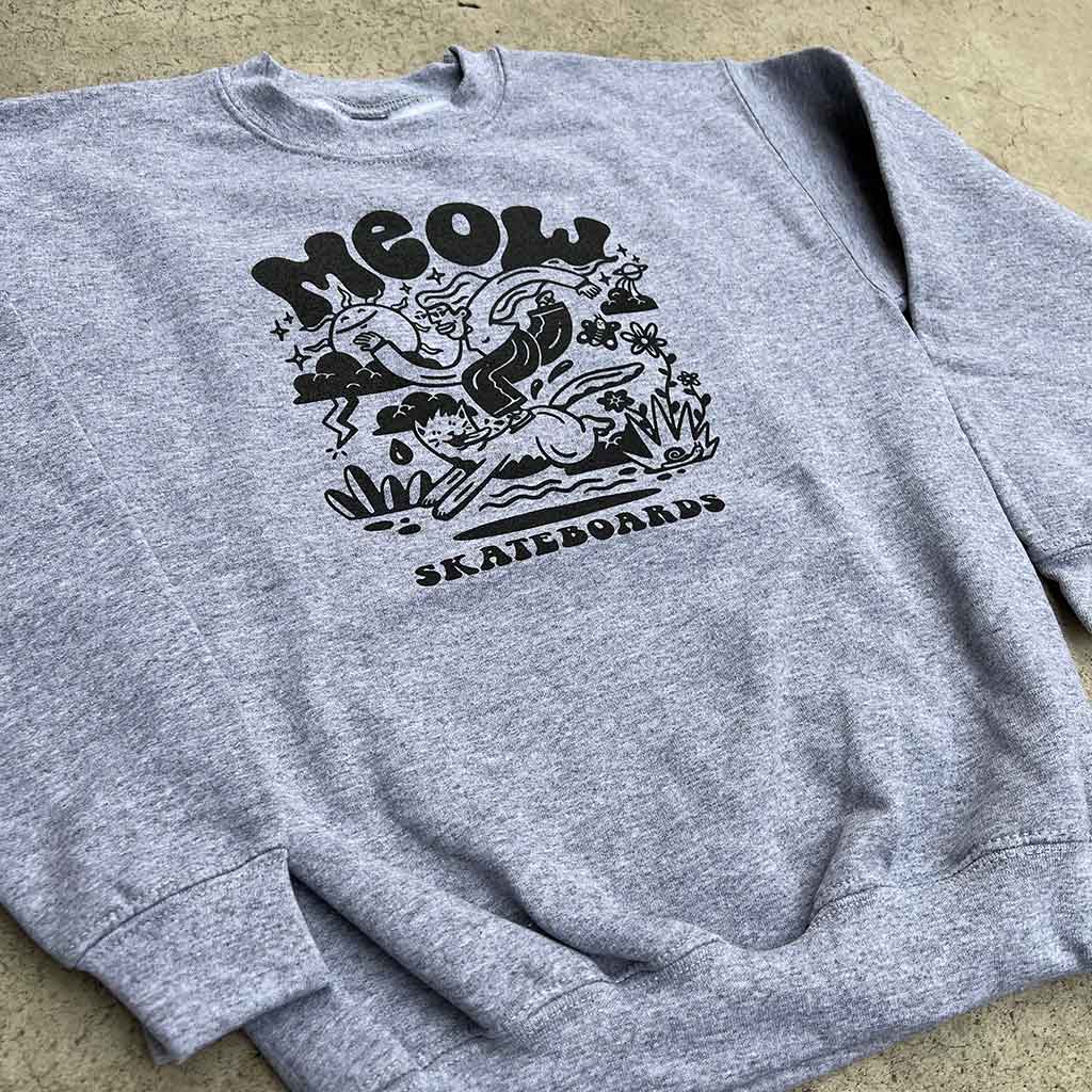 Gray sweatshirt with black graphic design on a concrete surface